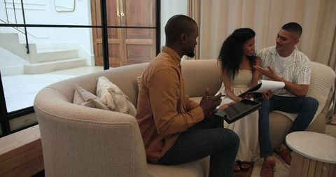 Friends sharing memories with photo album at home