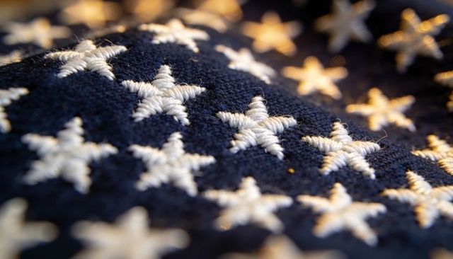 Displaying embroidered white stars on navy fabric with visible stitches and textured weave