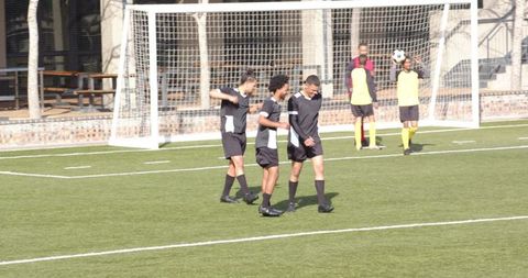 Soccer players practicing on field with enthusiastic team spirit