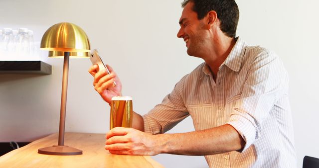 Cheerful Man Enjoying Beer while Using Smartphone at Cafe - Download Free Stock Images Pikwizard.com