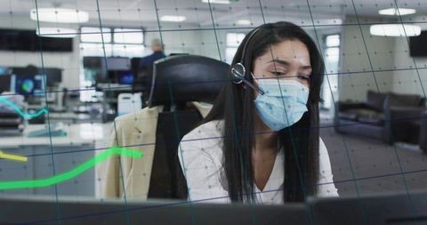 Answering customer calls wearing mask and headset in open office with glass partition