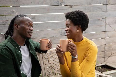Couple Enjoying Coffee on Patio Bench in Cozy Atmosphere