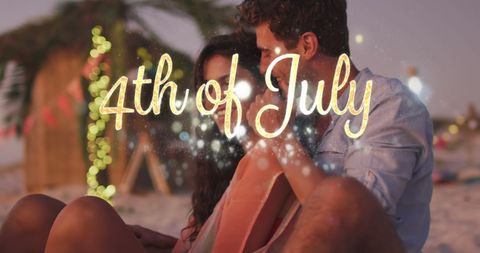 Couple embracing on beach with july 4th celebration lights