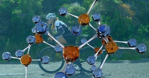 Innovative Sport and Science Fusion: Woman Cycling with Molecular Overlay