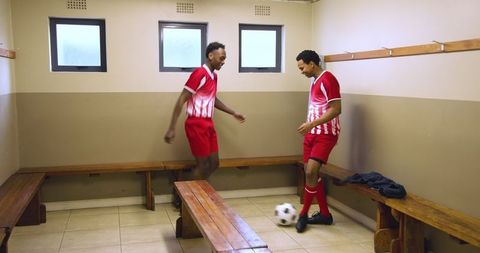 Soccer players mastering ball control in locker room