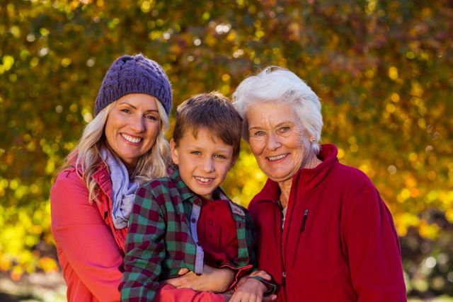 Portrait of boy with mother and grandmother at park during autumn