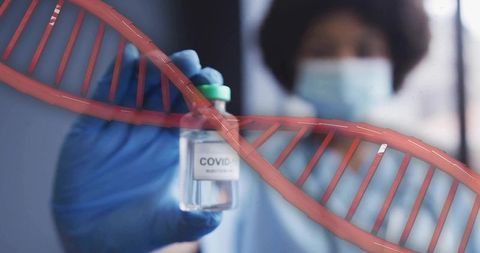 Holding covid-19 vaccine vial with dna helix overlay representing genomics and research