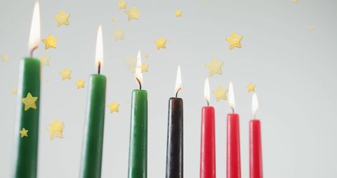 Kwanzaa Celebration with Glowing Kinara Candles and Falling Stars