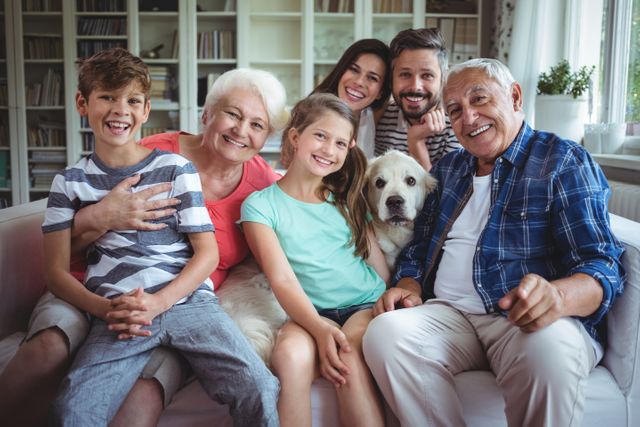 Portrait of happy multi-generation family sitting on sofa in living room at home