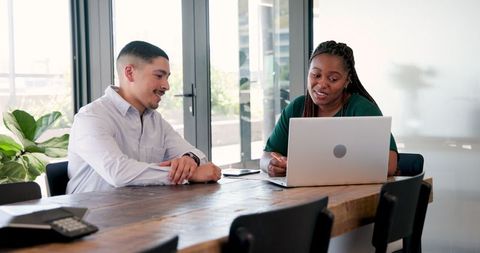 Business professionals discussing project in office with laptop
