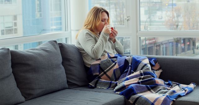 Woman Drinking Hot Beverage on Sofa Near Window - Download Free Stock Images Pikwizard.com