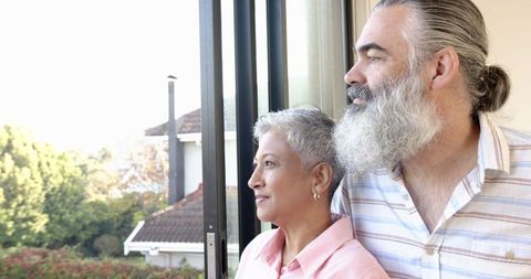 Senior Couple Enjoying Residential View from Sliding Glass Door