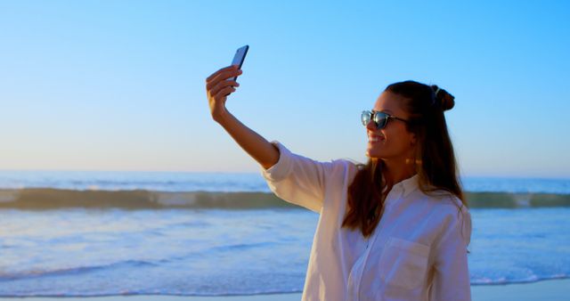 Smiling Woman Taking Selfie at Beach During Sunset - Download Free Stock Images Pikwizard.com