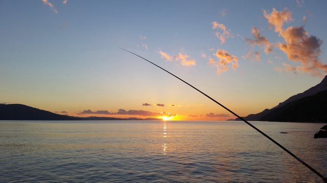 Fishing Rod Near Body of Water during Sunset - Download Free Stock Photos Pikwizard.com