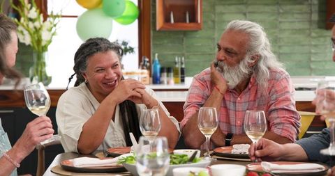 Senior Friends Enjoying Wine and Conversation During Meal