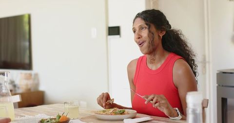 African american woman enjoying healthy lunch at modern bright dining table