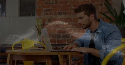 Entrepreneur working on laptop in contemporary cafe space