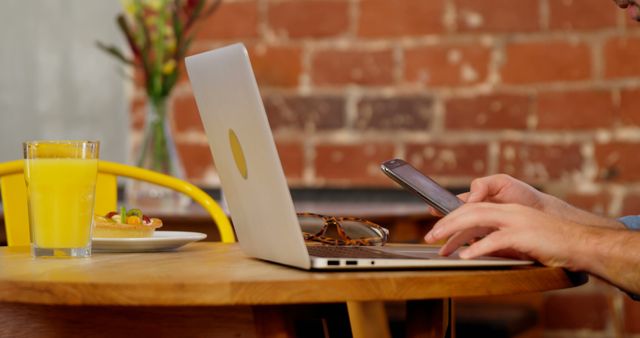 Person Using Smartphone and Laptop at Cozy Cafe - Download Free Stock Images Pikwizard.com