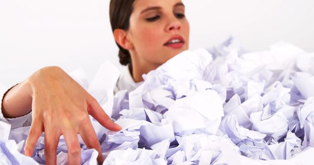 Overwhelmed Woman Sifting Through Crumpled Papers in Office - Download Free Stock Images Pikwizard.com