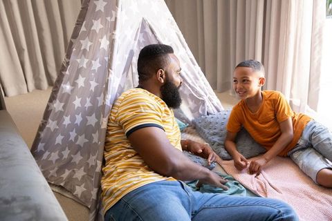Father and son bonding in cozy indoor teepee setting