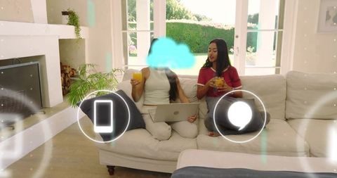Friends on Sofa Sharing Laptop and Sipping Orange Juice in Bright Modern Living Room