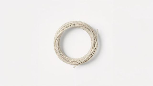 Minimalist coiled light beige rope on white background