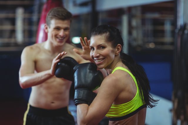 Boxers practicing together in a fitness studio, wearing boxing gloves and sports attire. This image can be used for promoting fitness programs, boxing classes, gym memberships, or sportswear. It highlights teamwork, motivation, and an active lifestyle.