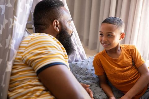 African American Father Bonding with Son in Homemade Tent