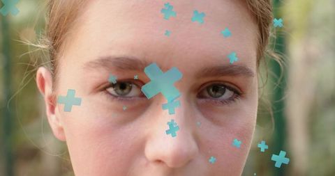 Closeup young woman looking at camera with turquoise AR plus overlays on face outdoors
