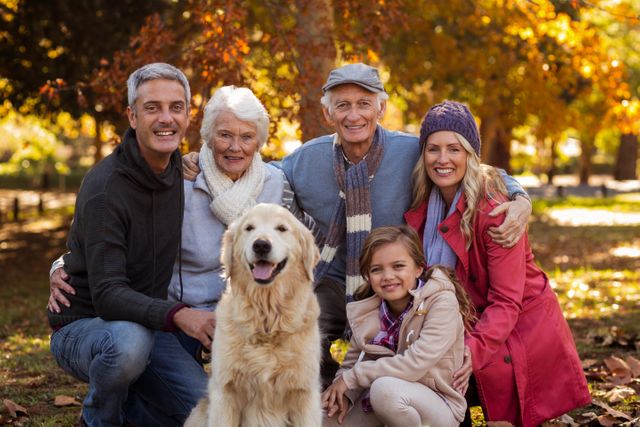 Family enjoying quality time in a park during autumn. Perfect for use in advertisements, family-oriented content, pet-friendly promotions, and seasonal campaigns.