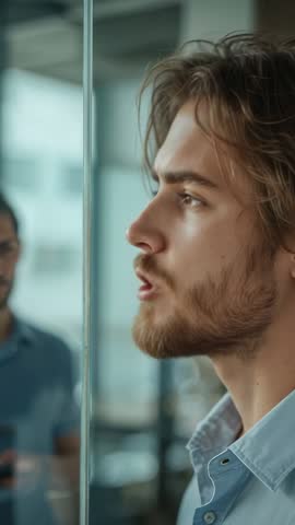 Young Man Speaking at Glass Partition Vertical Corporate Communication Presentation Video