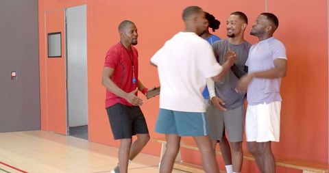 Coach greeting basketball players on gym bench, pregame huddle and team motivation