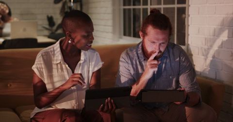 Collaborating late night analyzing digital tablets office environment