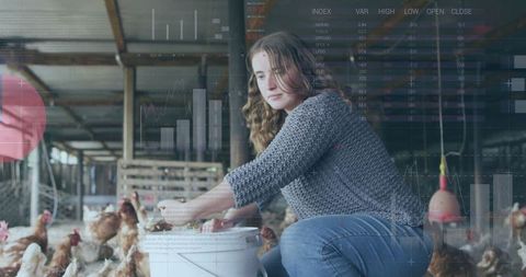 Young woman working in poultry barn feeding chickens naturally