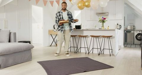 Man Sets Up Surprise Anniversary Celebration with Balloons in Cozy Kitchen