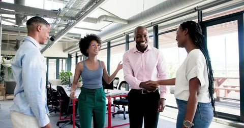 Multiracial team celebrating new business launch in office