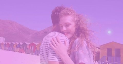 Romantic Embrace on Sunny Beach with Vibrant Beach Houses