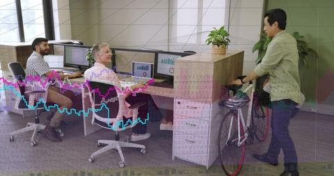 Coworkers greeting colleague arriving by bicycle in bright office encouraging bike commute