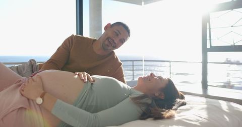 Expecting couple enjoying relaxed morning by ocean view