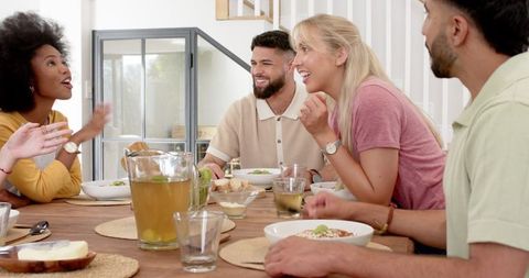 Diverse friends enjoying meal at home bringing joy and camaraderie