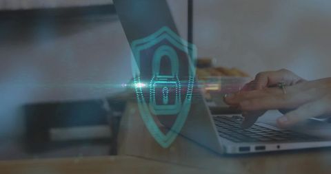 Hands on Laptop with Digital Shield Overlay Demonstrating Cybersecurity