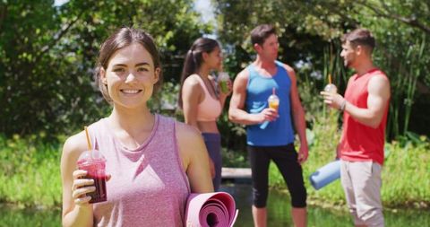 Active Friends Enjoying Healthy Refreshments After Outdoor Yoga