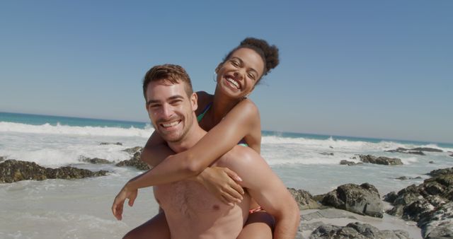 Image showing a joyful couple enjoying their time at the beach on a sunny day, perfect for promoting vacation packages, travel blogs, summer ad campaigns, and articles about relationships and fun outdoor activities.