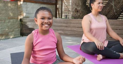 Mother and Daughter Practicing Meditation Outdoors on Yoga Mats