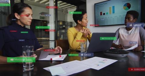 Diverse sales team discussing analytics and strategy around laptop with social overlays
