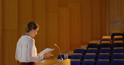 Businesswoman practicing speech in empty auditorium
