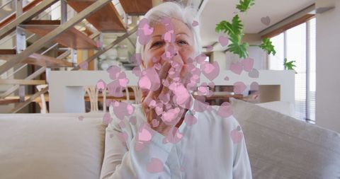 Senior woman sending virtual hearts during video call