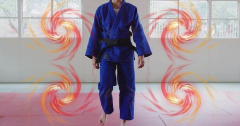 Teen female judo athlete standing in blue gi with black belt and dynamic motion swirls