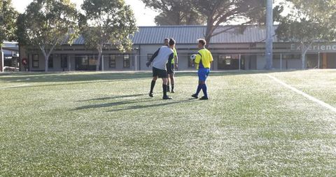 Youth soccer players developing teamwork on sunny field