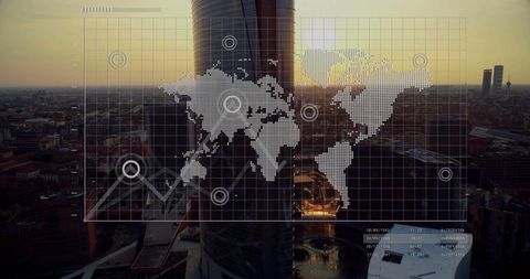 Futuristic skyscraper with world map data overlay at sunset